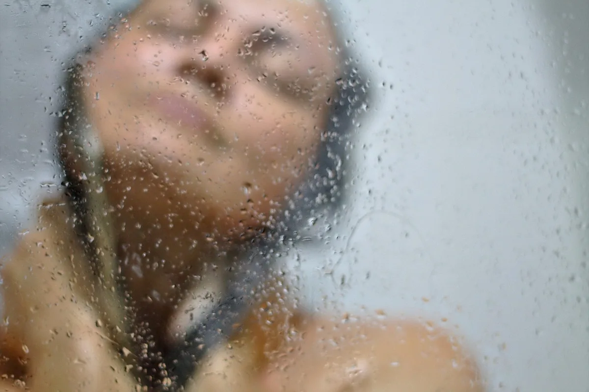 Cotons et serviette propre posés sur un plan de salle de bain, ambiance hygiène intime