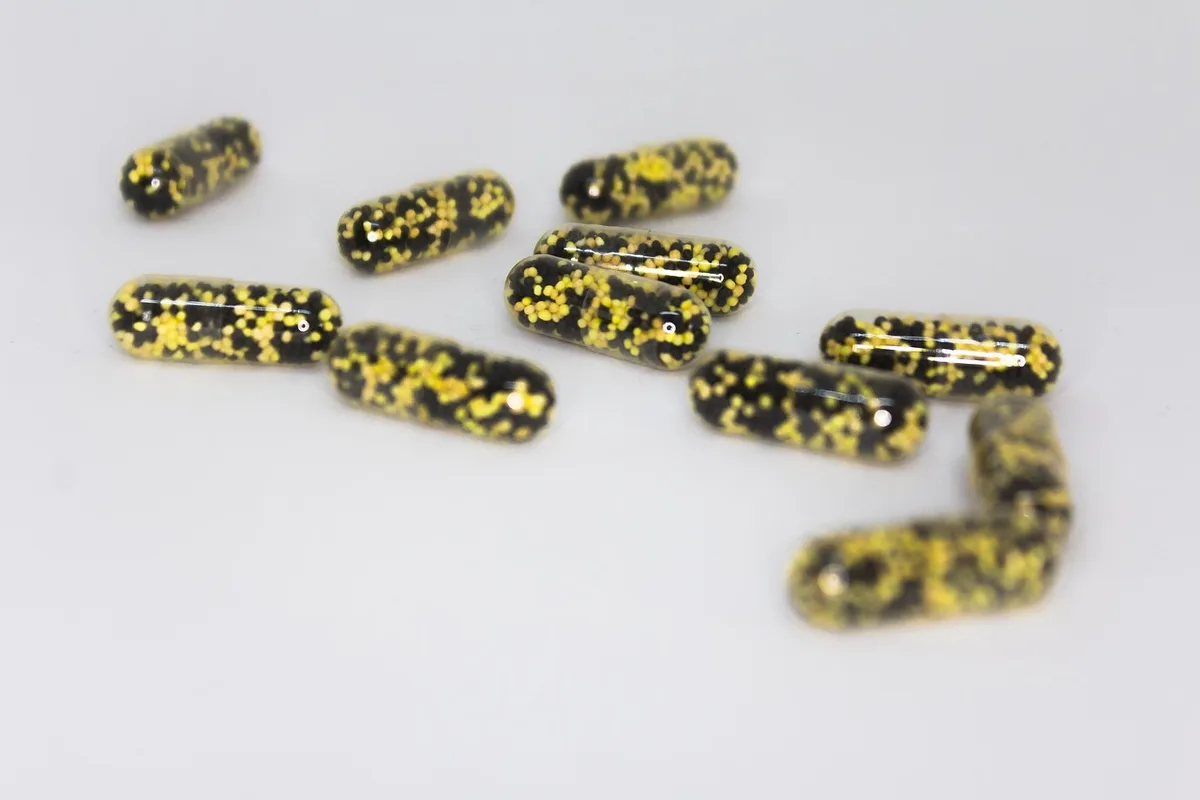 Gélules probiotiques sur une cuillère, emballage générique non marqué